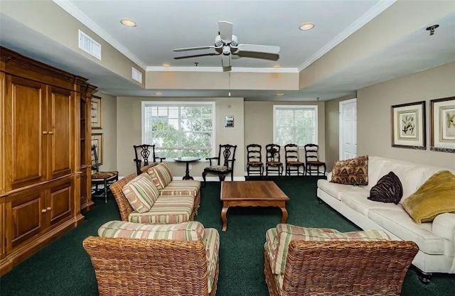 living room featuring crown molding, dark carpet, a tray ceiling, and ceiling fan