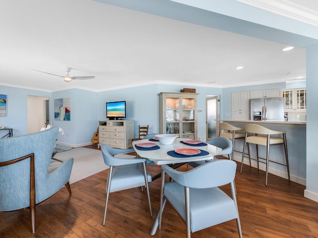 dining space with dark wood-type flooring, ceiling fan, and crown molding