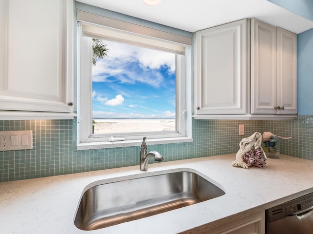 kitchen featuring sink, light stone counters, tasteful backsplash, dishwasher, and white cabinets