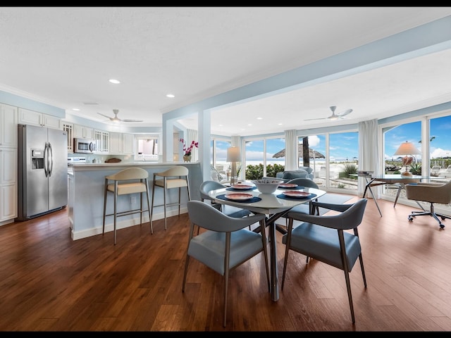 dining area with ornamental molding, dark wood-type flooring, and ceiling fan