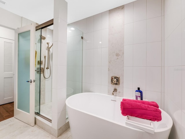 bathroom with independent shower and bath and tile walls