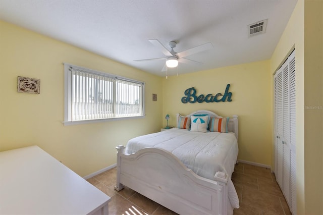 bedroom with ceiling fan, a closet, and light tile patterned floors