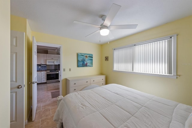 bedroom with a spacious closet, a closet, light tile patterned flooring, and ceiling fan