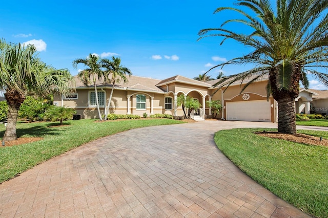 mediterranean / spanish house with a garage and a front lawn