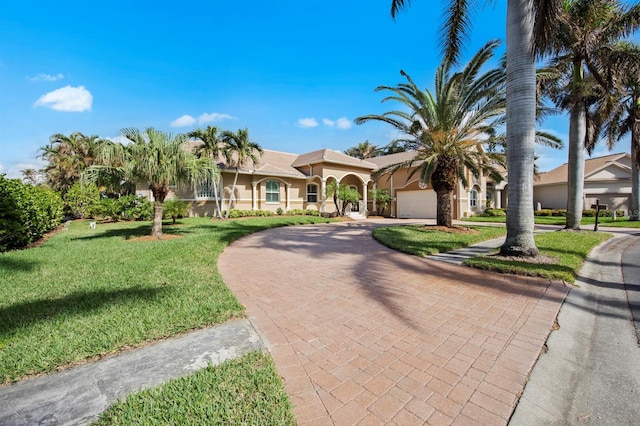 mediterranean / spanish home featuring a garage and a front yard