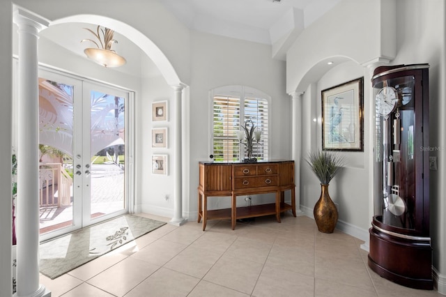 foyer entrance featuring decorative columns, light tile patterned flooring, and french doors