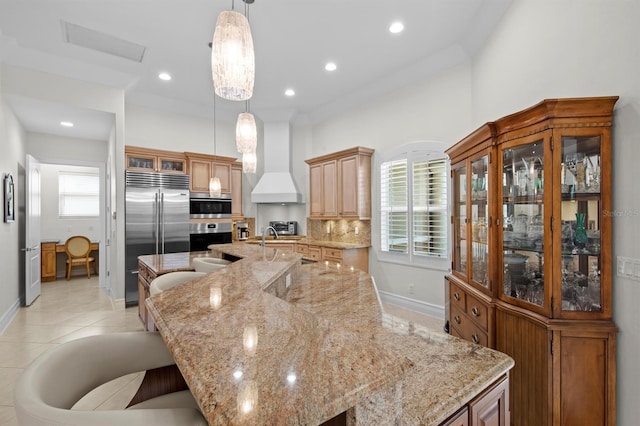 kitchen featuring premium range hood, a spacious island, appliances with stainless steel finishes, and hanging light fixtures