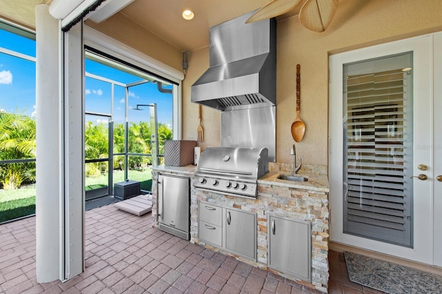 view of patio featuring sink, a lanai, ceiling fan, area for grilling, and an outdoor kitchen