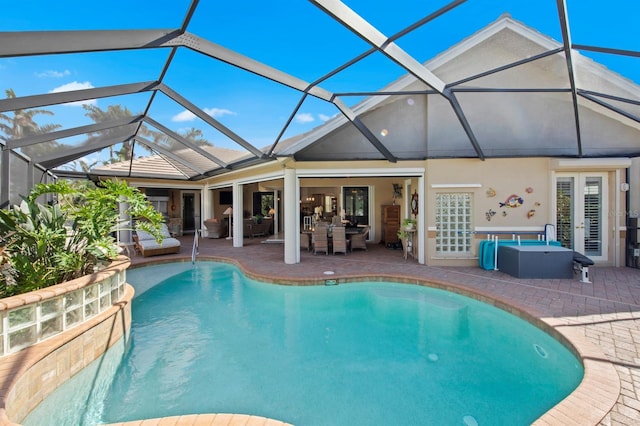 view of swimming pool with a hot tub, a patio, and a lanai