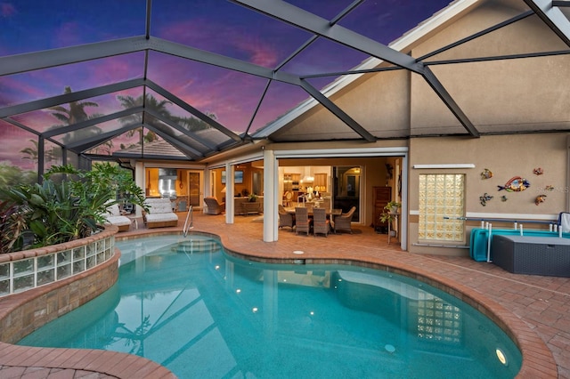 pool at dusk with an outdoor living space, a lanai, and a patio area