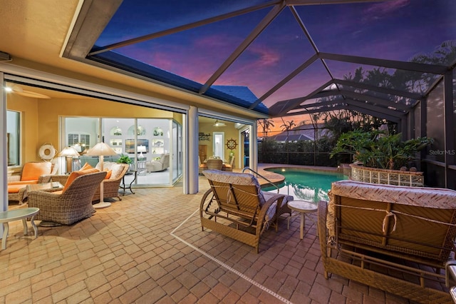 patio terrace at dusk with outdoor lounge area and glass enclosure