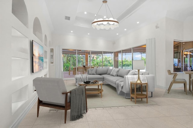 living room featuring light tile patterned floors, crown molding, a notable chandelier, a wealth of natural light, and a raised ceiling