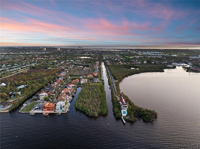 aerial view at dusk featuring a water view