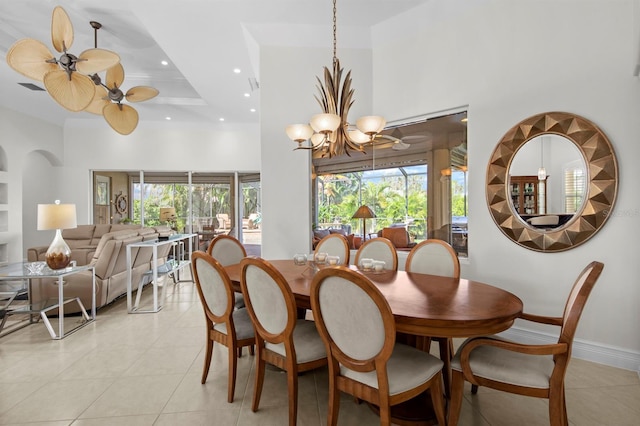 tiled dining area with a wealth of natural light, a raised ceiling, and a high ceiling