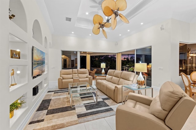 living room featuring ceiling fan, a high ceiling, and light tile patterned floors