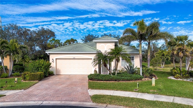 mediterranean / spanish-style house with a garage and a front lawn