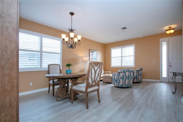 dining space with an inviting chandelier and light wood-type flooring