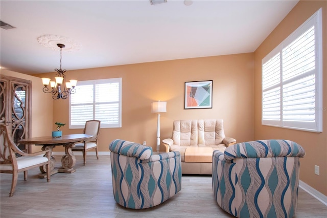 living room with a chandelier and light hardwood / wood-style flooring