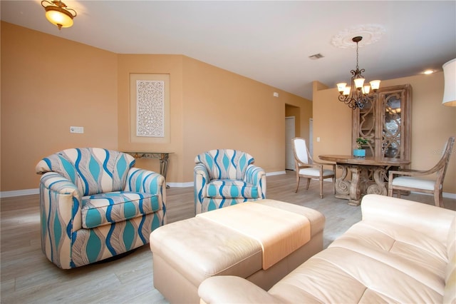 living room featuring an inviting chandelier and light hardwood / wood-style floors