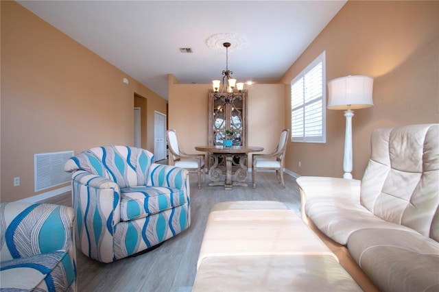 living room featuring an inviting chandelier and hardwood / wood-style flooring