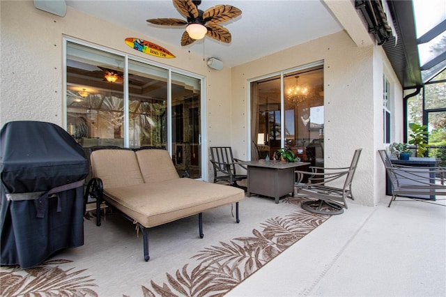 view of patio with ceiling fan, area for grilling, and glass enclosure