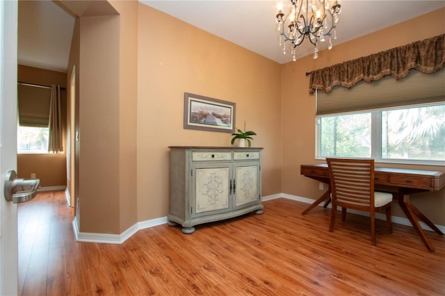 office area featuring a notable chandelier and light wood-type flooring