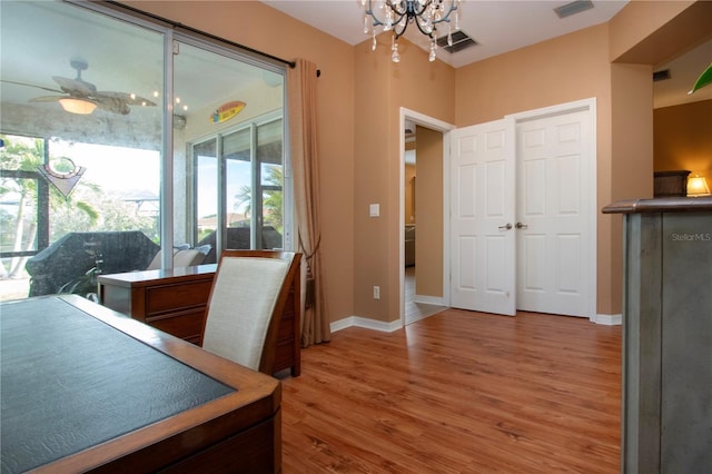 office area featuring ceiling fan with notable chandelier and hardwood / wood-style floors