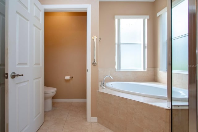 bathroom with tiled tub, tile patterned floors, and toilet