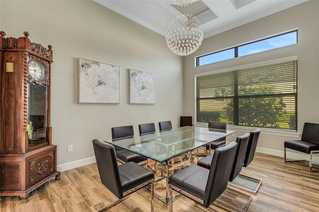 dining area with crown molding, light hardwood / wood-style flooring, and a notable chandelier