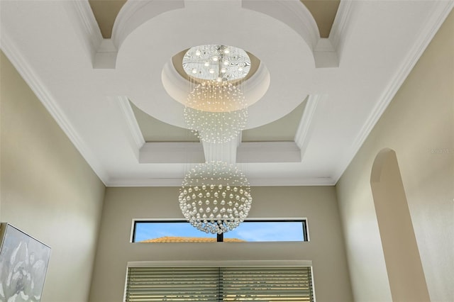 details with crown molding, a raised ceiling, and a chandelier