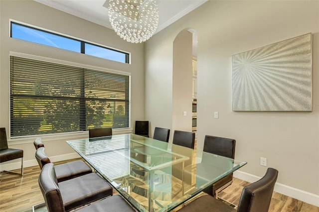 dining space with an inviting chandelier, wood-type flooring, and crown molding