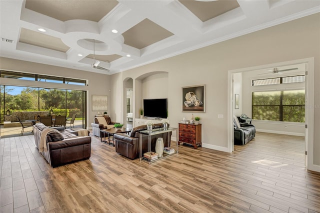 living room featuring a towering ceiling, plenty of natural light, coffered ceiling, and light hardwood / wood-style flooring