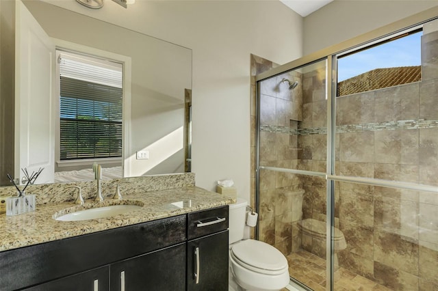 bathroom featuring walk in shower, vanity, and toilet