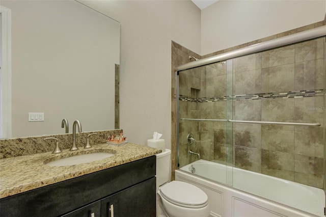 full bathroom featuring vanity, bath / shower combo with glass door, and toilet