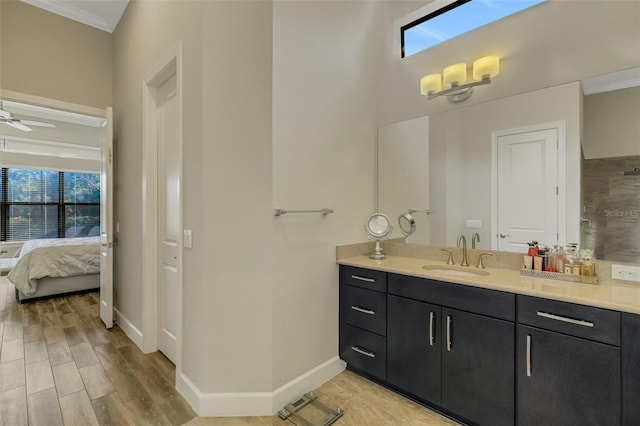 bathroom featuring vanity, wood-type flooring, crown molding, and ceiling fan