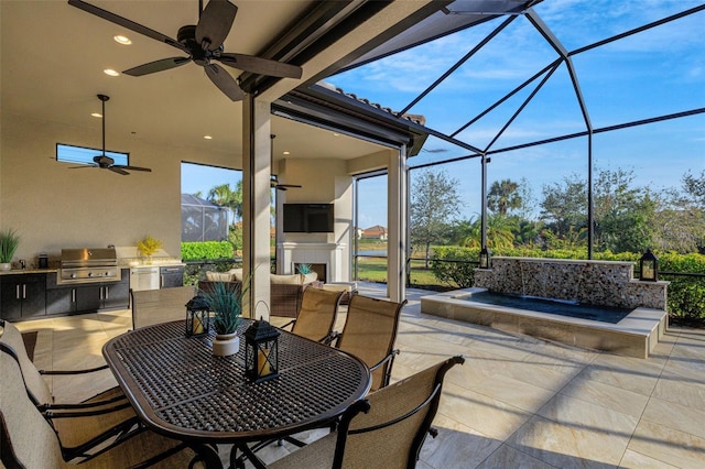 view of patio / terrace featuring exterior fireplace, a lanai, grilling area, and an outdoor kitchen