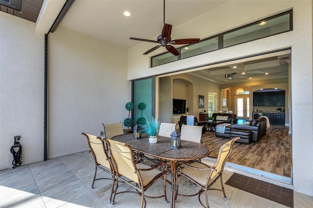 dining area featuring beamed ceiling, coffered ceiling, tile patterned floors, and ceiling fan