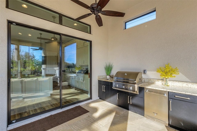 view of patio / terrace with ceiling fan, an outdoor kitchen, and a grill