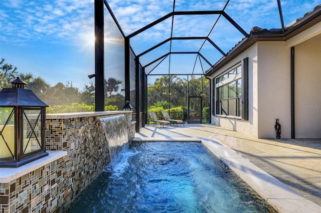 view of pool with a patio area and glass enclosure