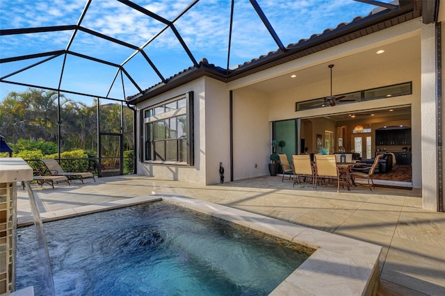 view of pool featuring a jacuzzi, a patio area, ceiling fan, and glass enclosure