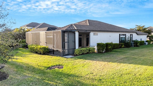 rear view of house with a lanai and a yard