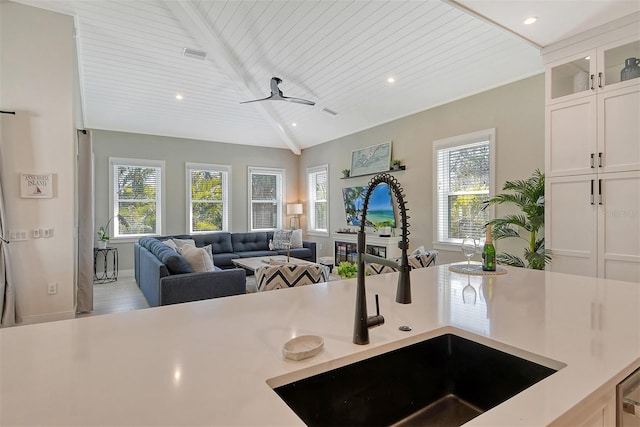 kitchen featuring white cabinetry, vaulted ceiling with beams, sink, and wooden ceiling