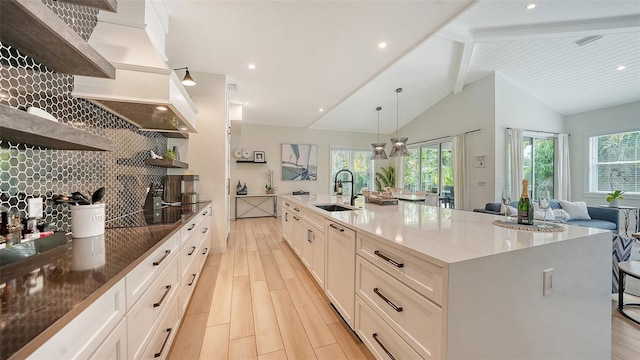 kitchen featuring a spacious island, white cabinetry, lofted ceiling with beams, and hanging light fixtures