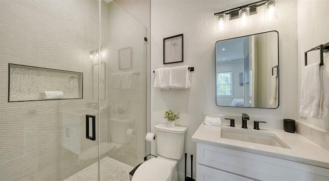 bathroom with a shower with door, vanity, and toilet