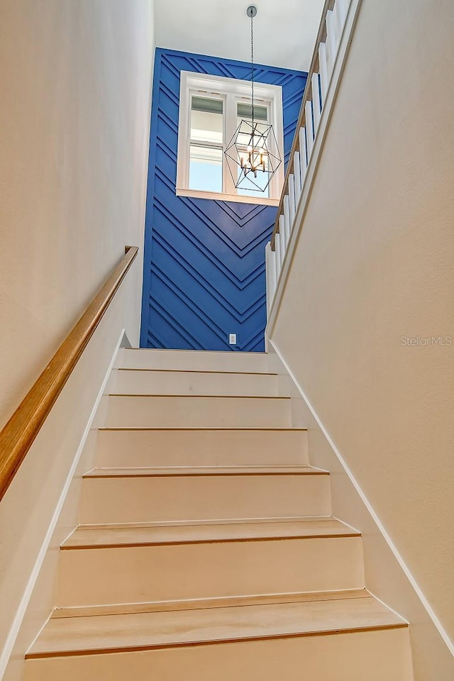 stairway featuring a chandelier