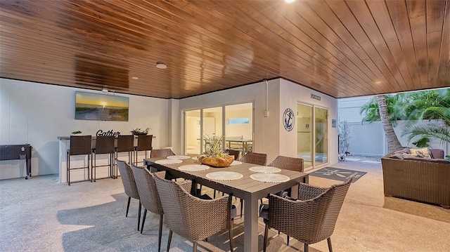 dining area with a healthy amount of sunlight, light colored carpet, and wooden ceiling