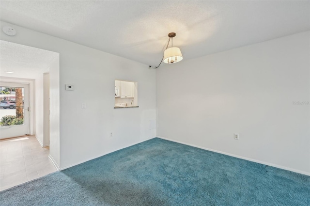 carpeted spare room featuring a textured ceiling