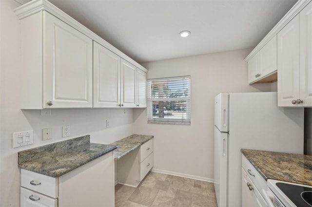 kitchen with white cabinetry, dark stone counters, and white electric range