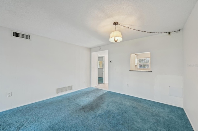 carpeted empty room with a textured ceiling