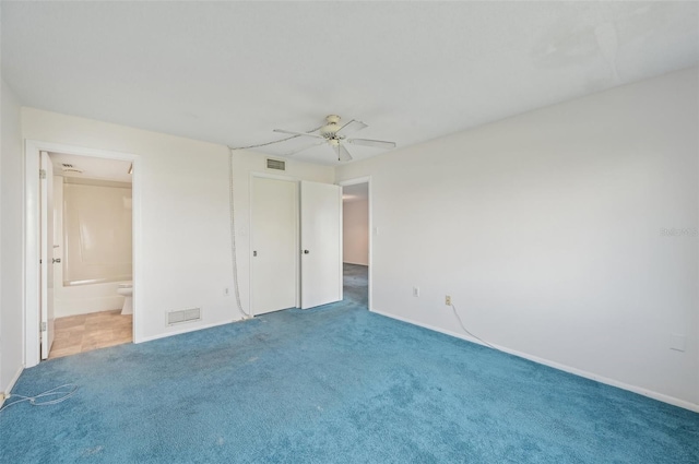 unfurnished bedroom with ensuite bath, ceiling fan, and carpet flooring